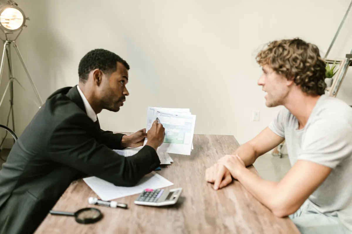 Advisor walking a client through paperwork at a desk during a consultation