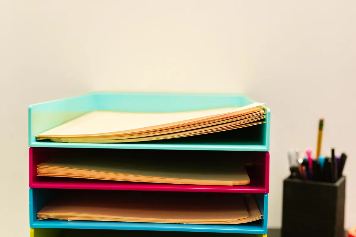 Stacked document trays holding paperwork on a desk