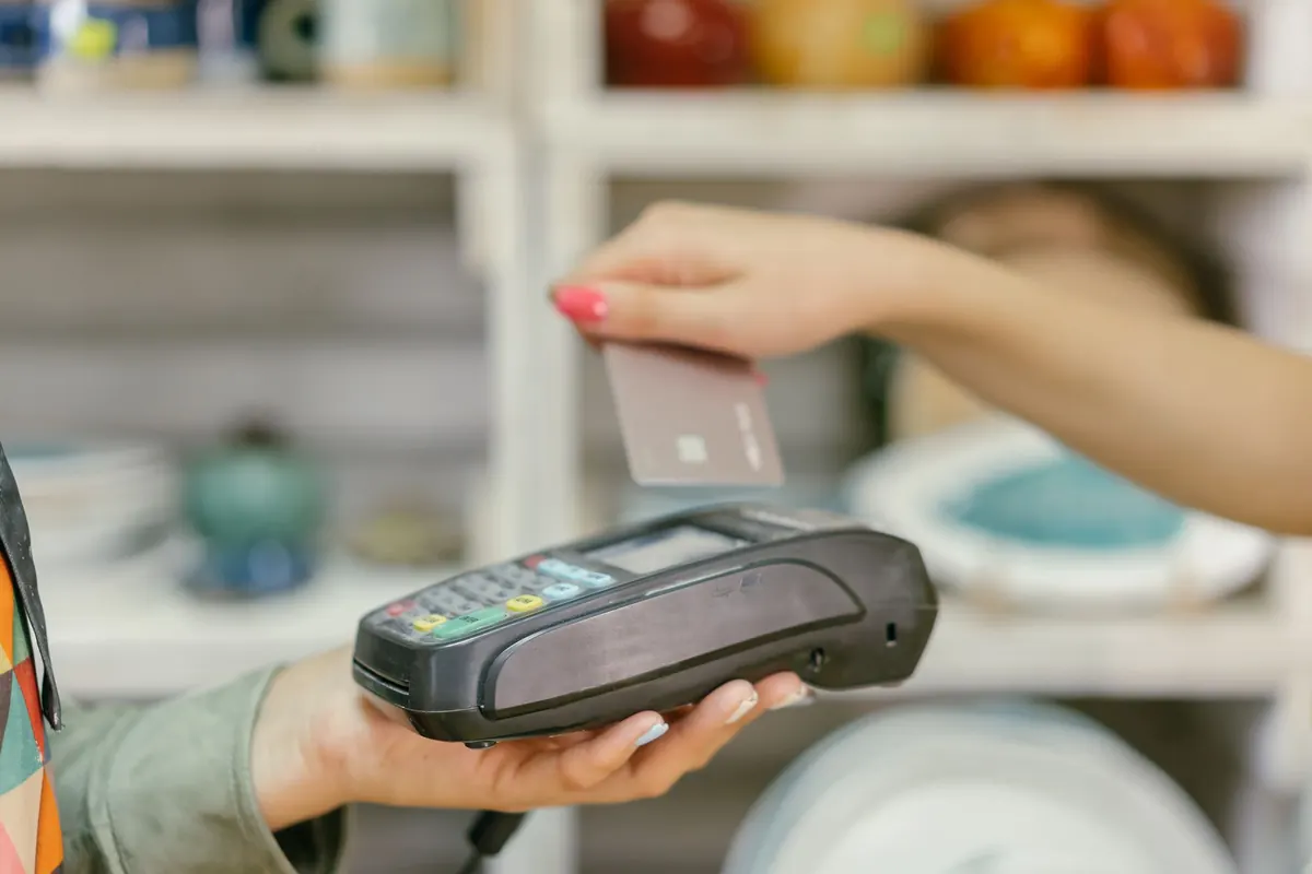 Hand using a card payment terminal