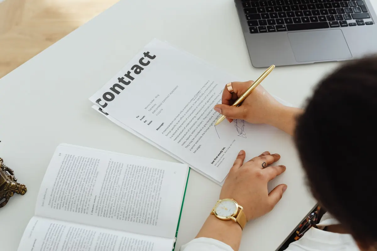 Professional signing a business contract at a desk