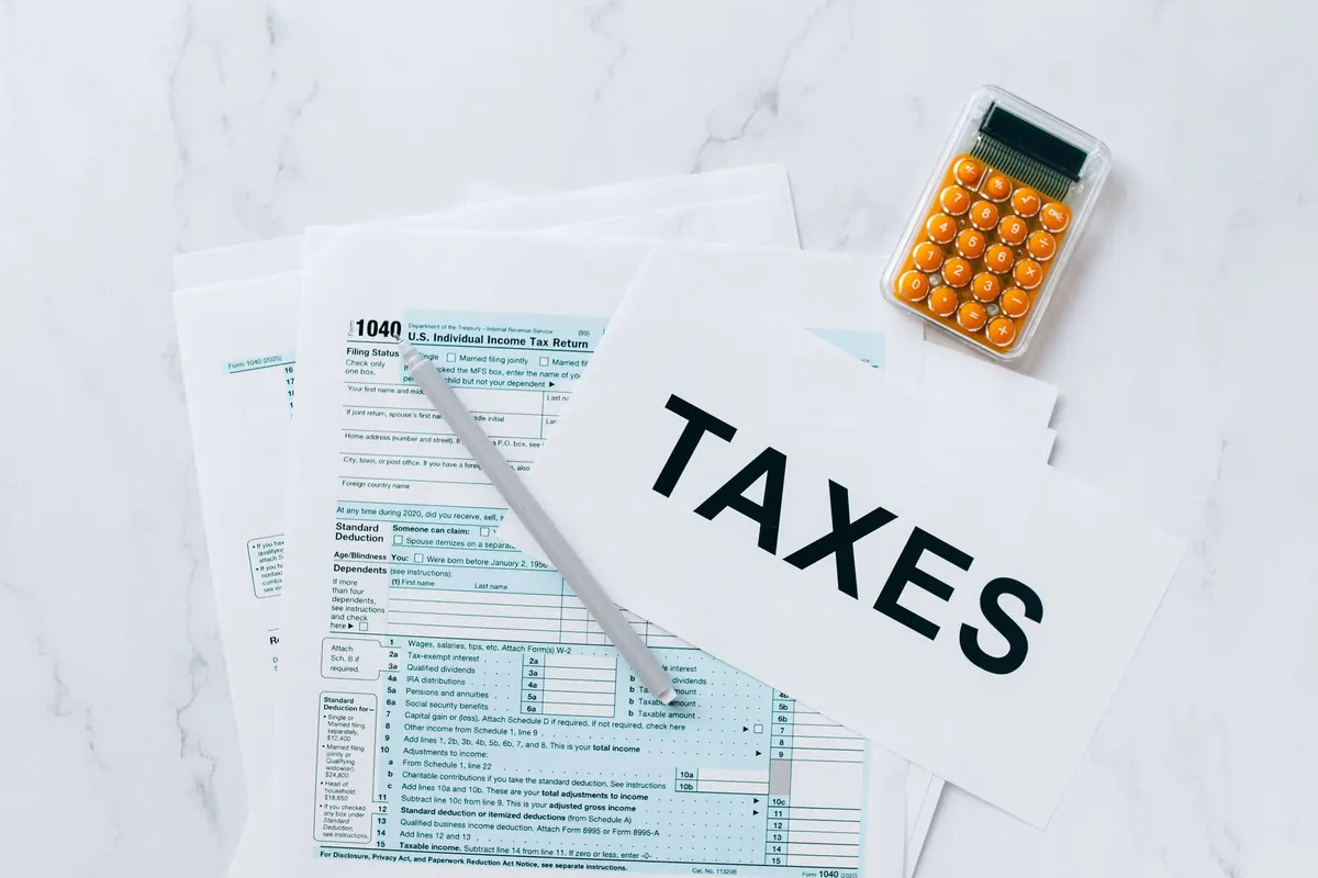 Top view of tax forms, a calculator and a pen