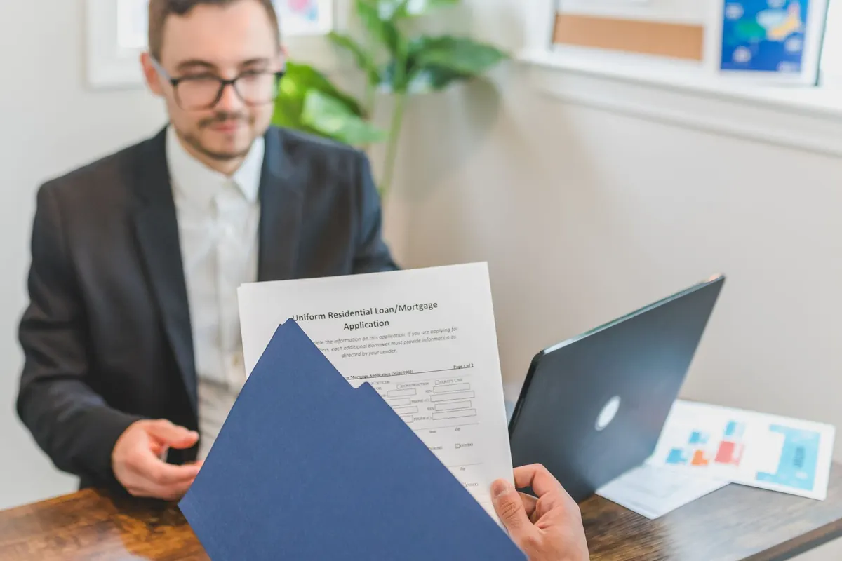 Person holding loan documents during a meeting