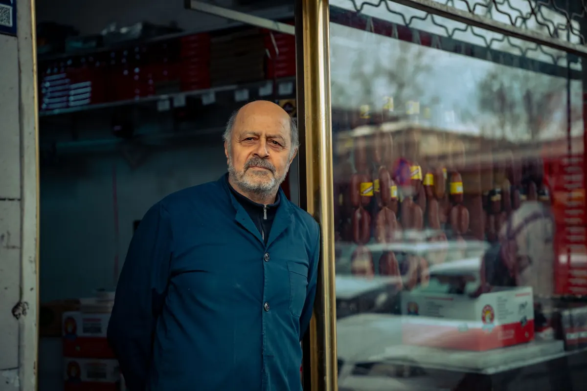 Shop owner standing outside his small store