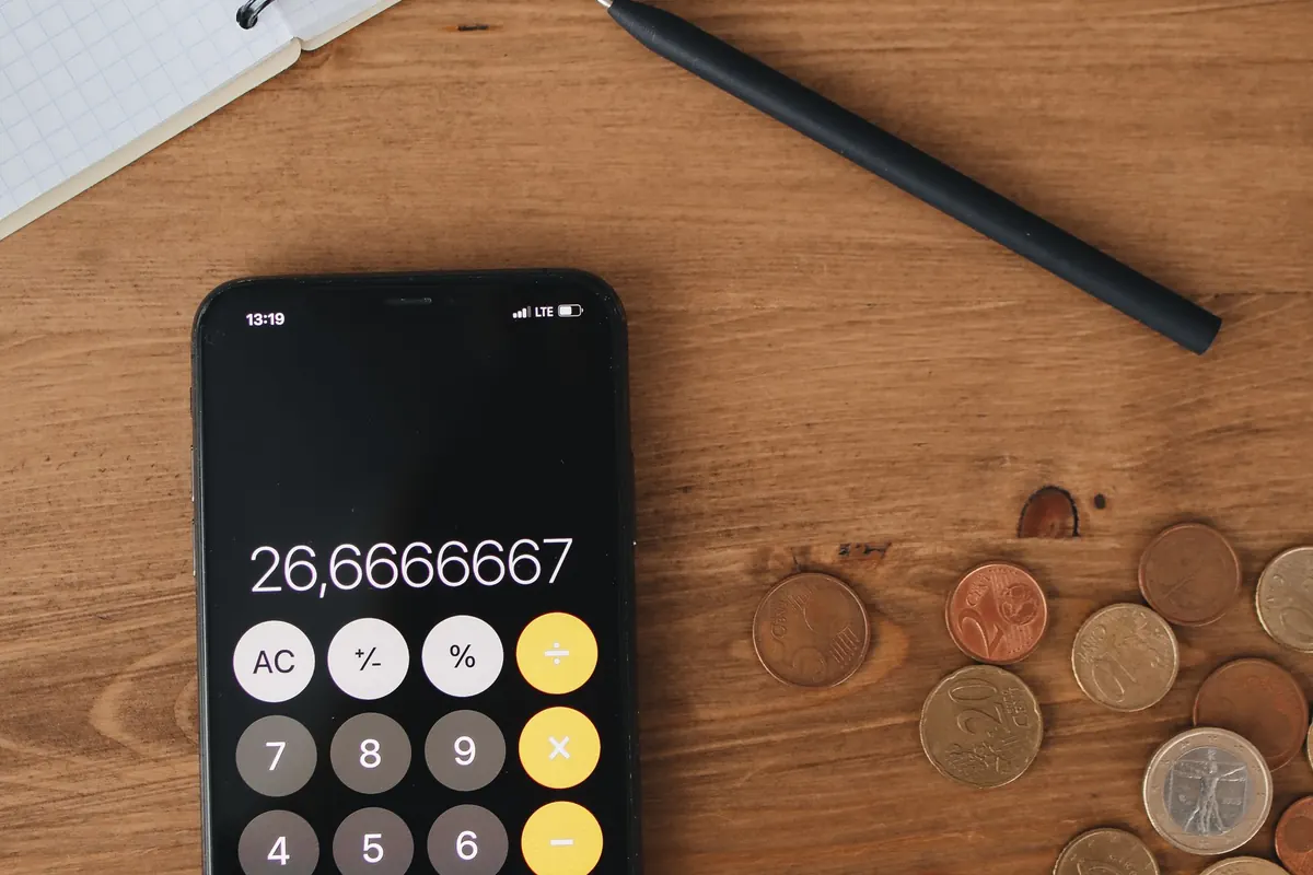 Notebook, pen, calculator and coins for budget planning